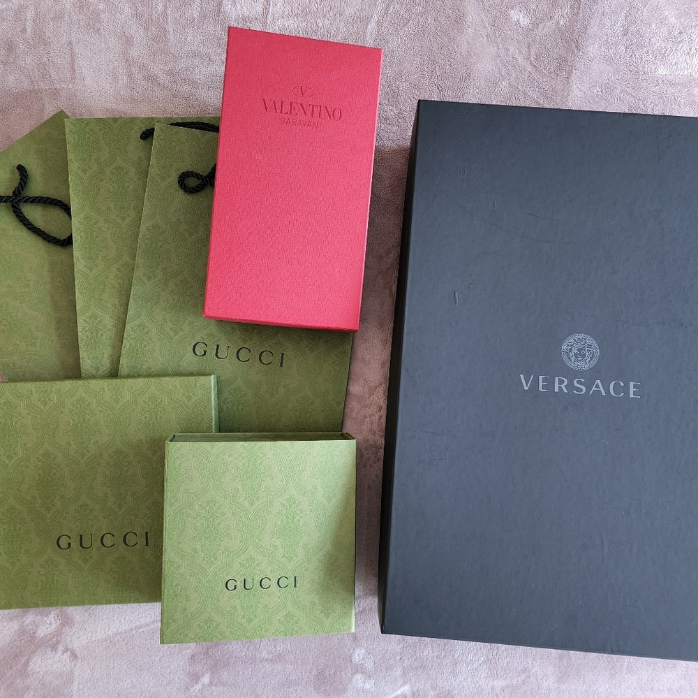 Gucci, Versace, and Valentino shopping bags and boxes